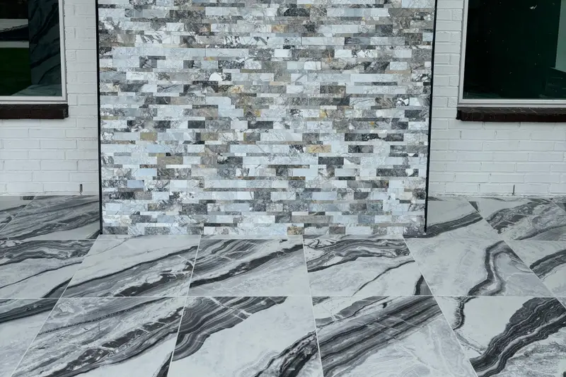 Black-and-white marble floor tiles running up to a stacked-stone accent wall set into white-painted brick, with a window on each side