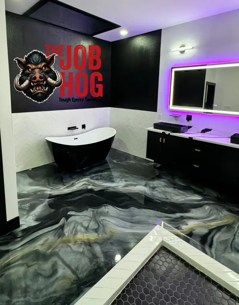 Bathroom with The Job Hog boar logo and the words Tough Epoxy Services on a black wall, a black freestanding tub against white herringbone tile, a black double vanity under a mirror with a purple LED backlight, and a swirled black, gray and gold metallic epoxy floor running to the white-tiled edge of a hexagon-tile shower